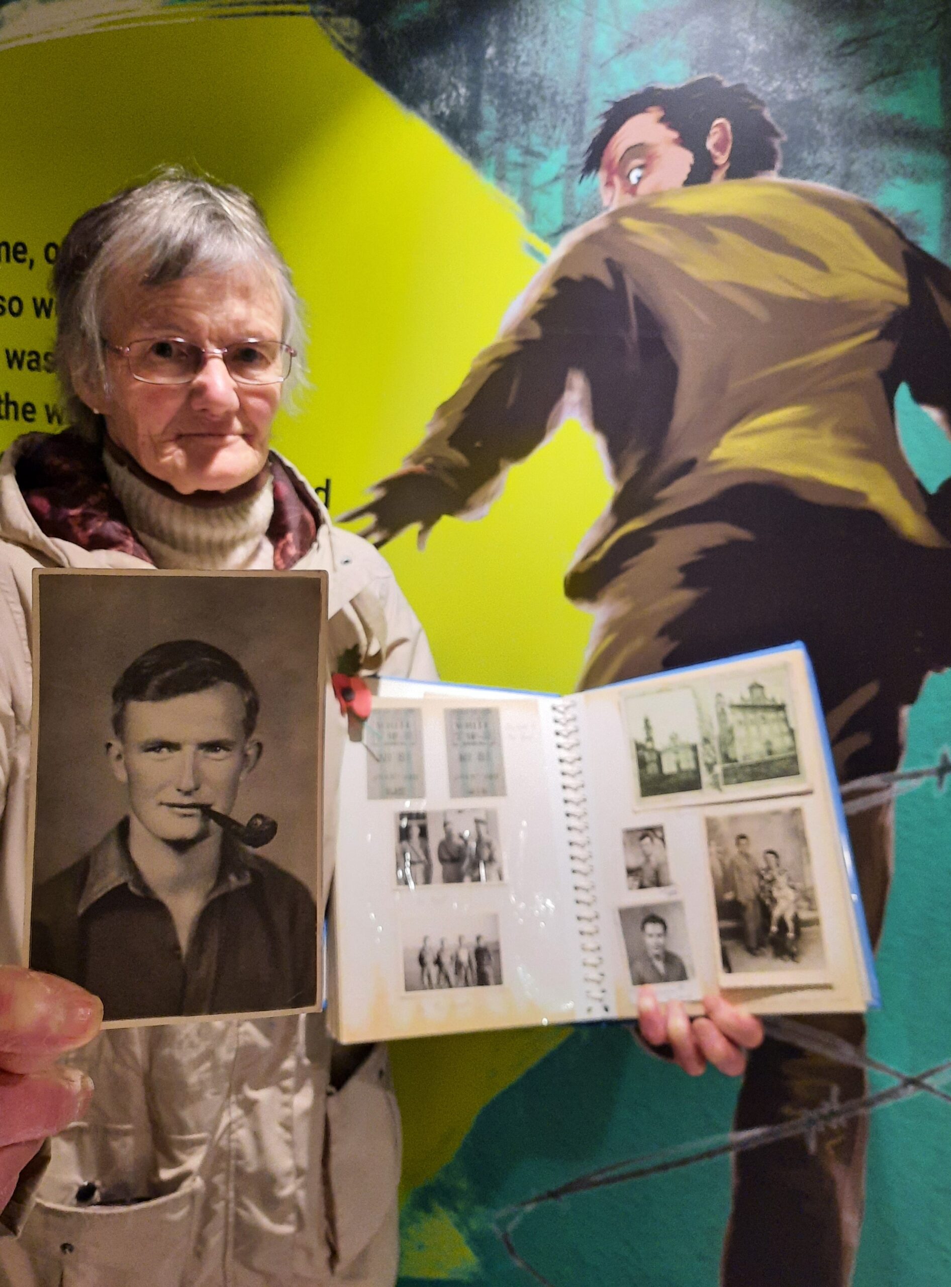 image of Noel Blunt's daughter with photo of him and a photo album dinated into the museum collection.